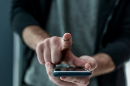 cropped shot of man touching smartphone screen with like sign on finger, phone addiction concept